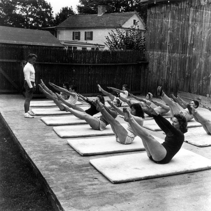Joseph Pilates guida una Mat Class di gruppo all’aperto, foto storica in bianco e nero
